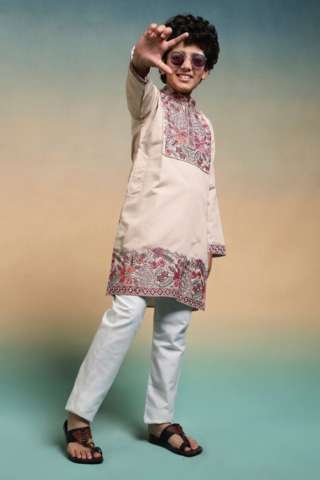 Person wearing a traditional kurta with floral patterns on a gradient background