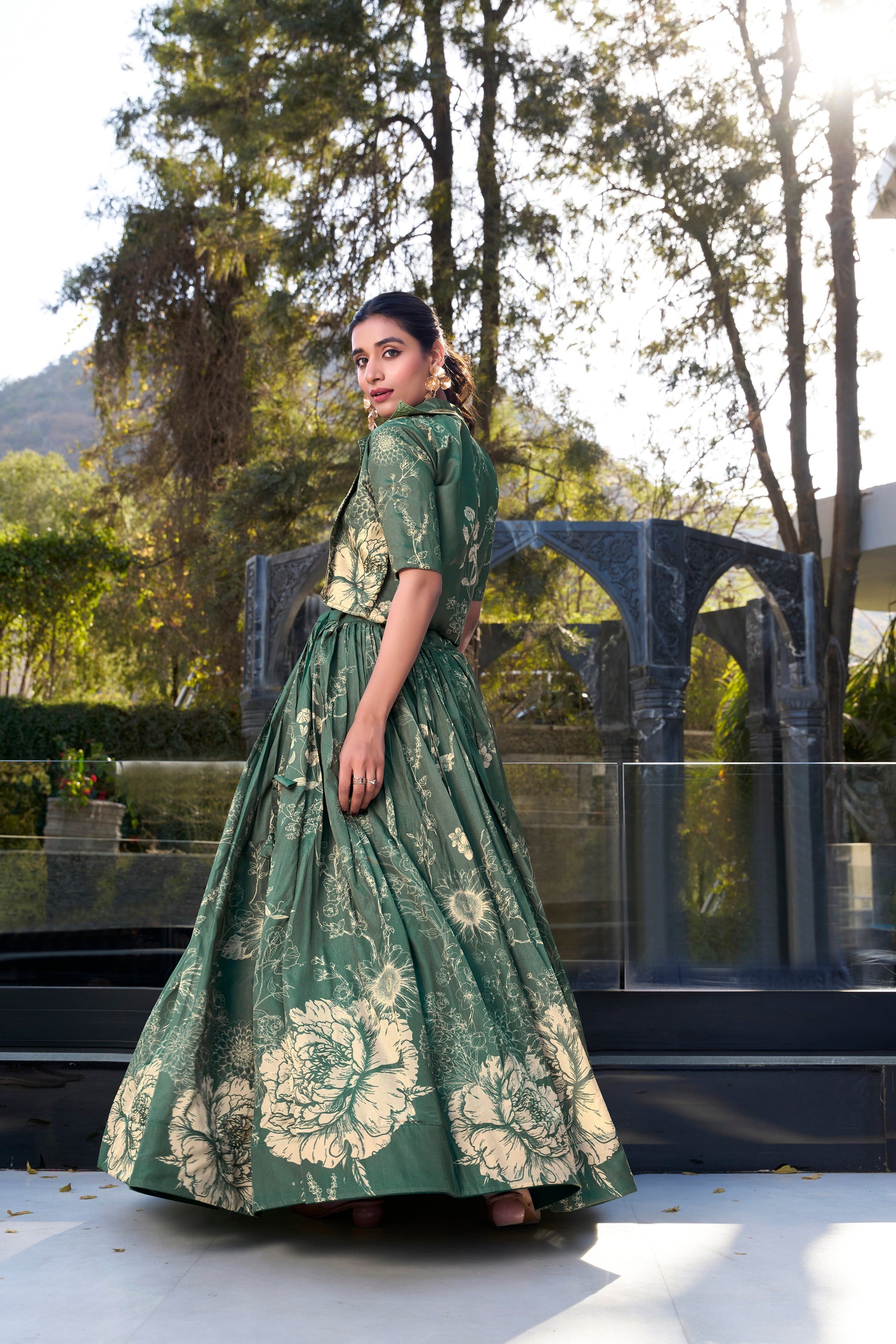 Side angle view of olive green printed lehenga with stitched blouse