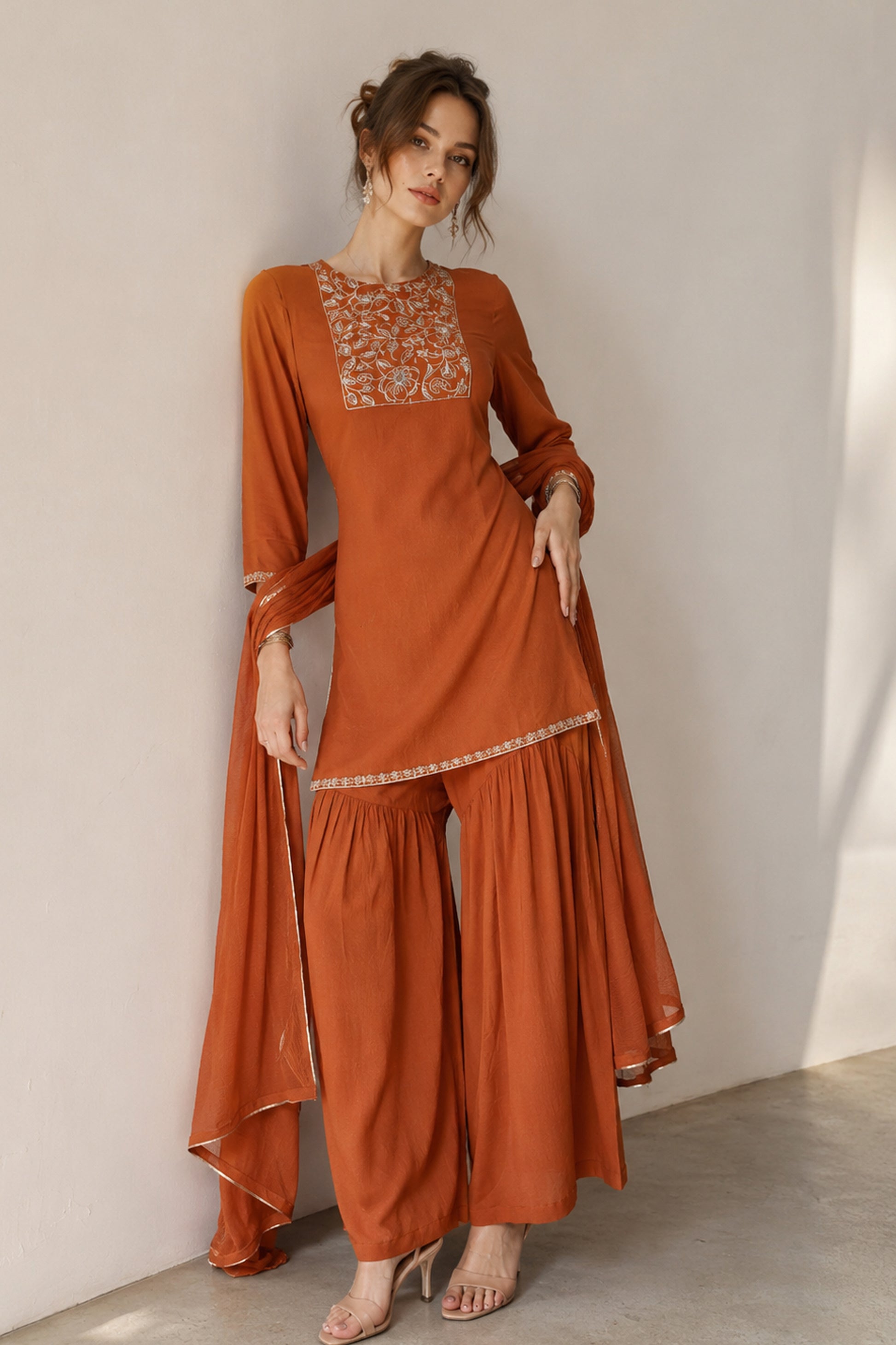 Full-length front view of orange silk sharara with floral printed thread work
