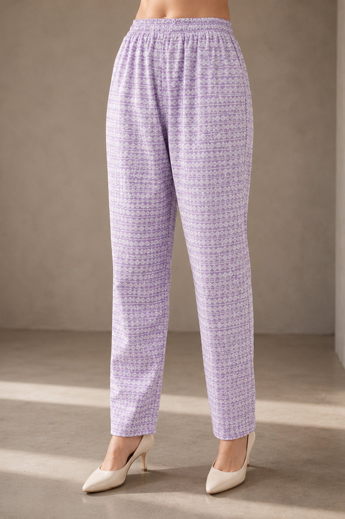 Purple patterned pants worn by a person on a neutral background