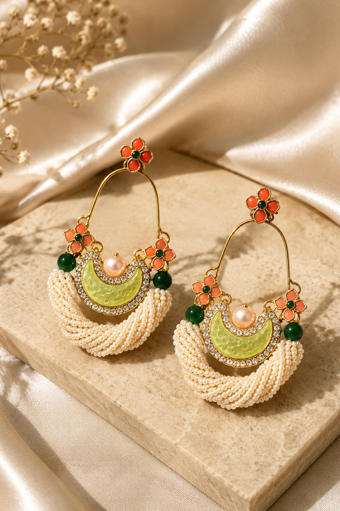 White beaded statement earrings with orange floral and green accents