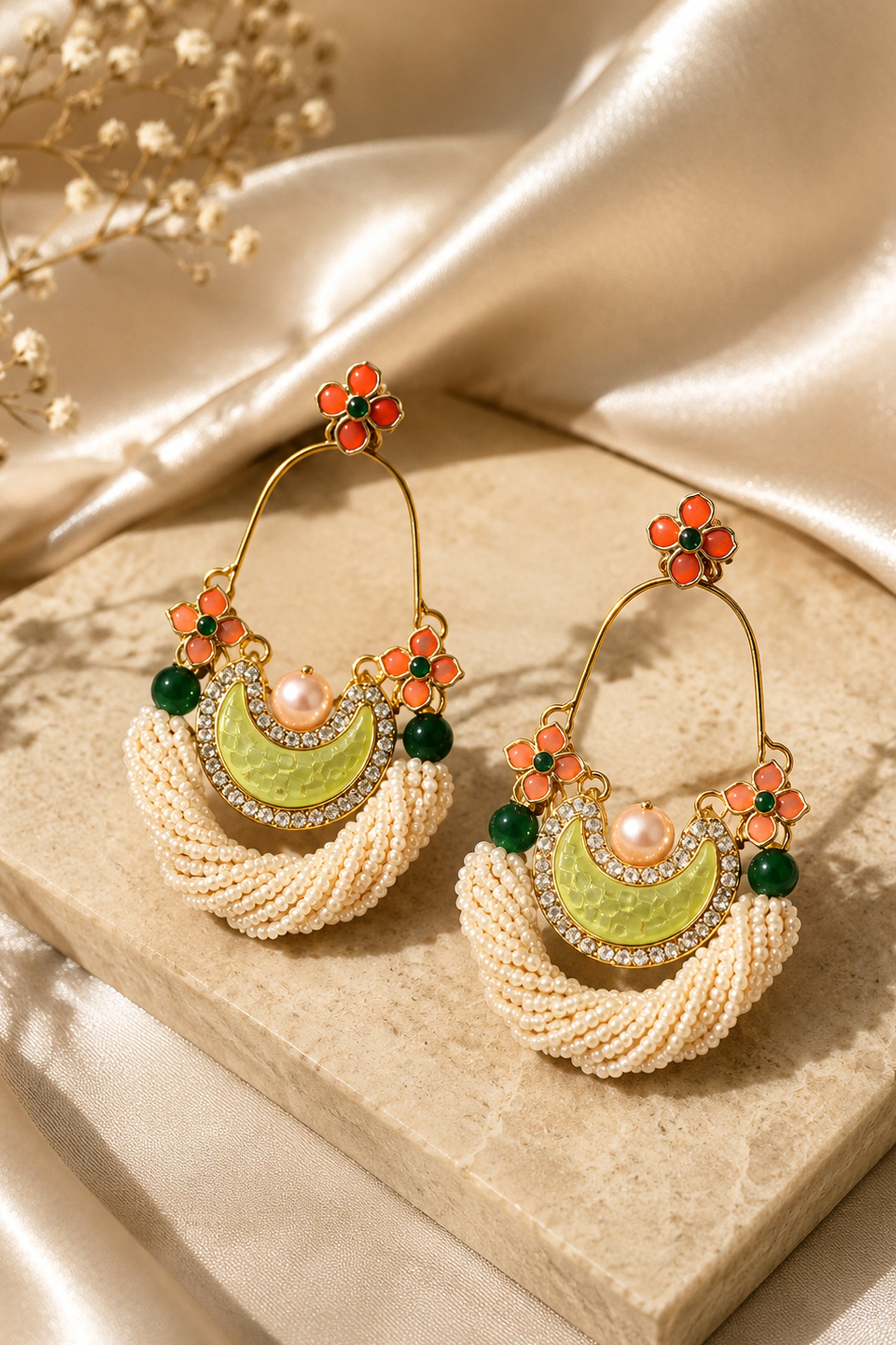White beaded statement earrings with orange floral and green accents