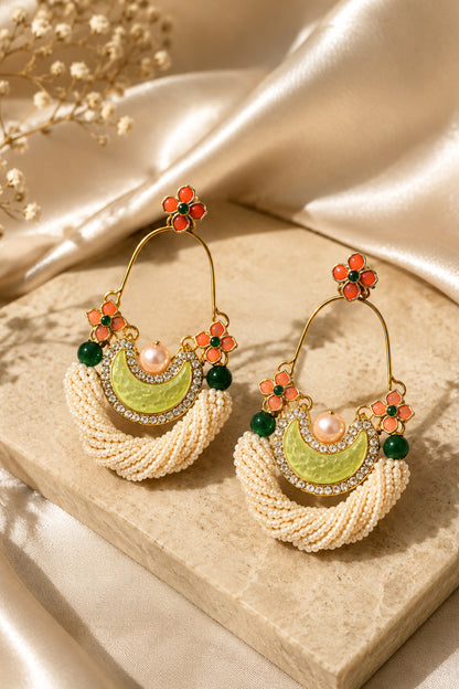 White beaded statement earrings with orange floral and green accents