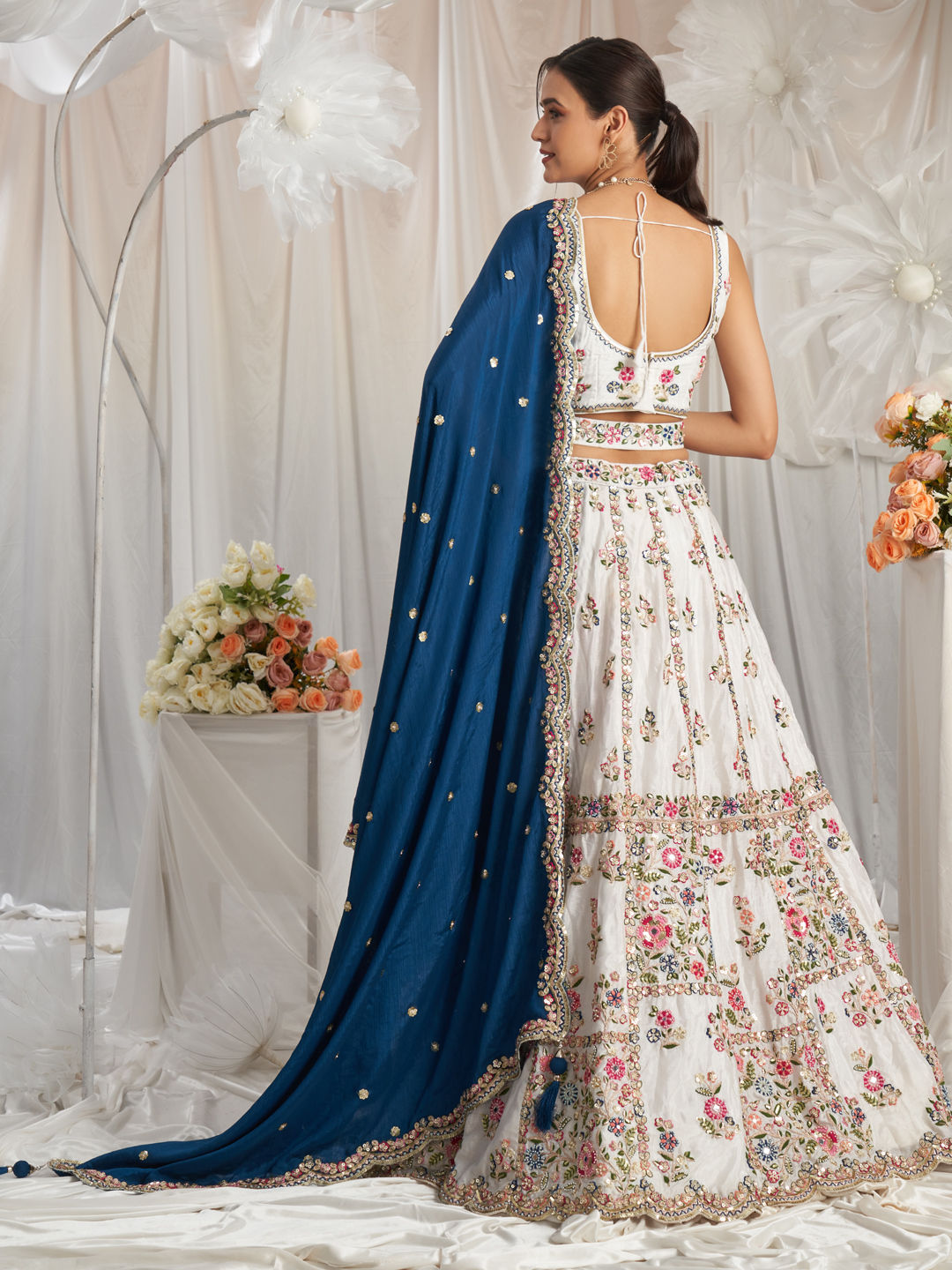 Back view of white lehenga choli with mirror accents