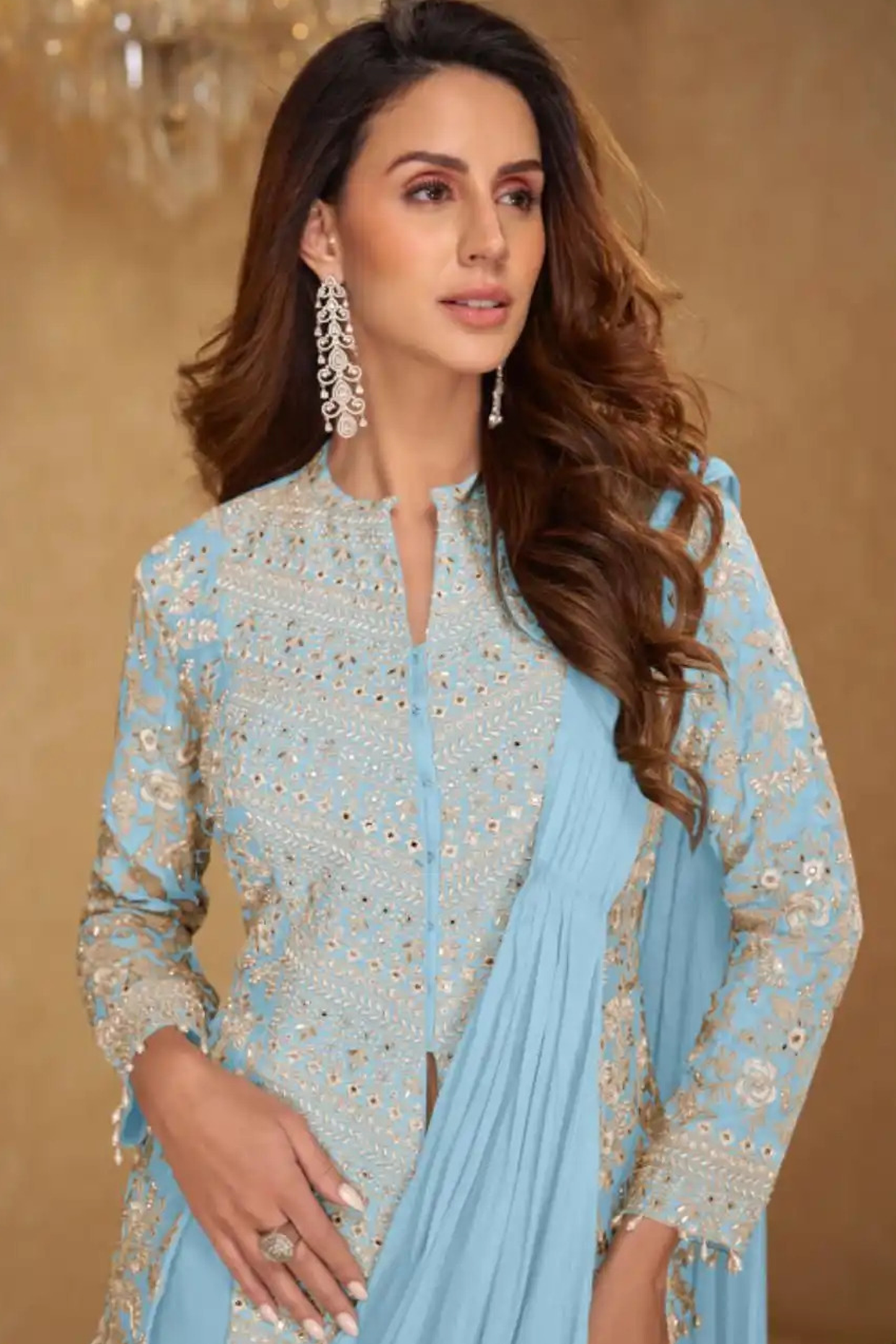 Woman wearing a light blue embroidered outfit with a matching dupatta against a beige background