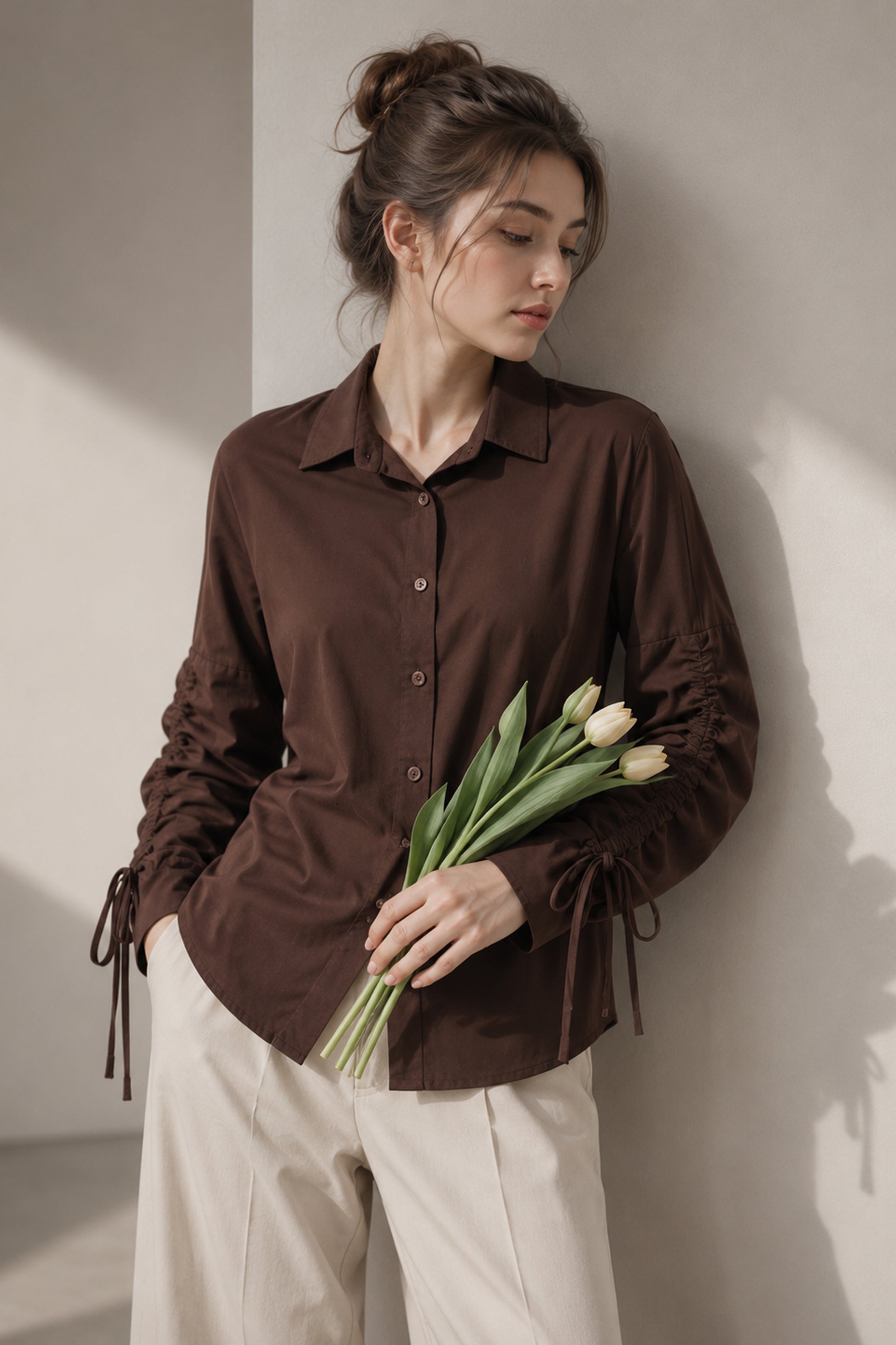 Seated model wearing the solid brown cotton shirt