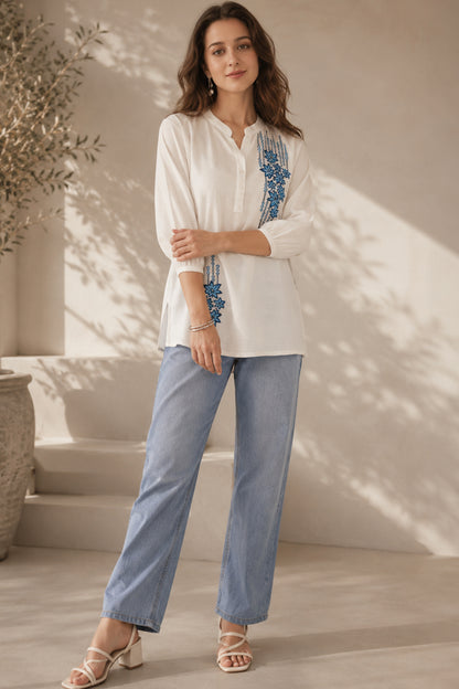 Woman wearing white womens tunic tops with floral embroidered detail